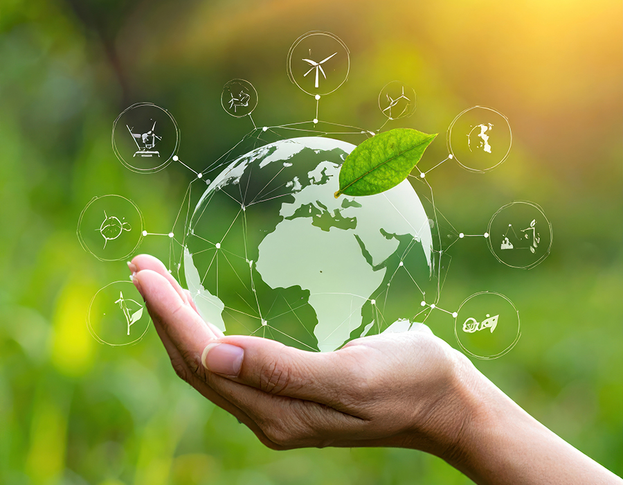 Symbolbild für Nachhaltigkeit in der Kunststoffverarbeitung: Hand hält digitale Erdkugel mit grünen Umweltsymbolen